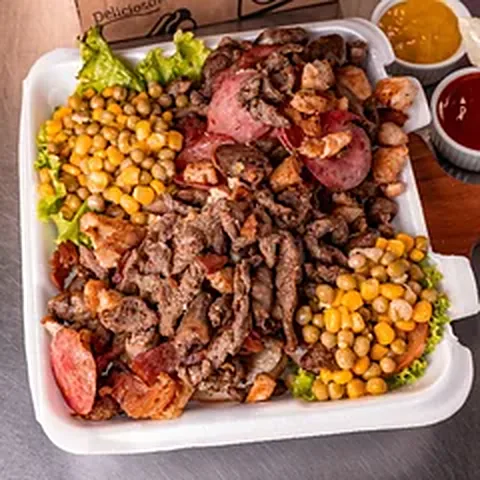 X-Tudo do Léo aberto no prato com carnes, calabresa, milho, alface e molhos